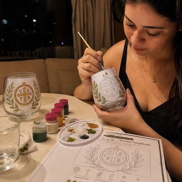 Mujer pintando una copa con un diseño delicado